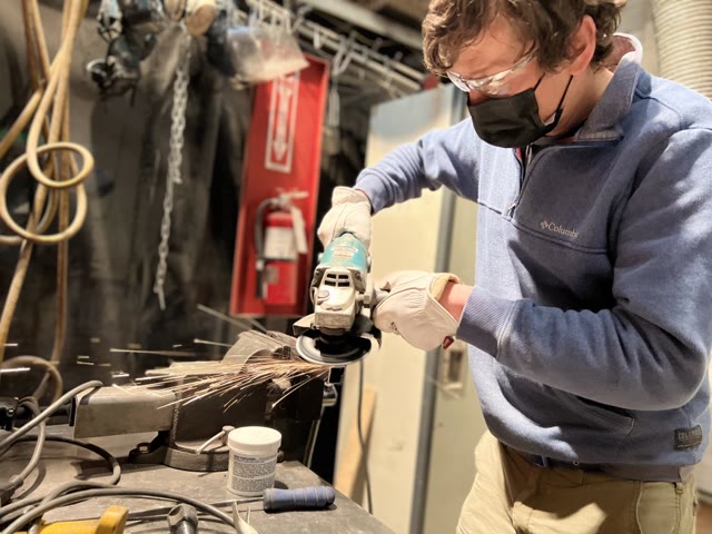 Member grinding metal in the metal shop